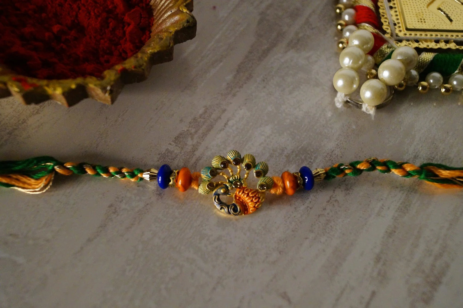 Peacock Stone Thread Rakhi by Kamakhyaa with Festive Wear, Jewellery, Multicolor, Natural Materials, Natural Threads, Peacock, Rakhi, Rakhis Ready to Ship, Regular Fit, Upcycled, Zari Threads at Kamakhyaa for sustainable fashion