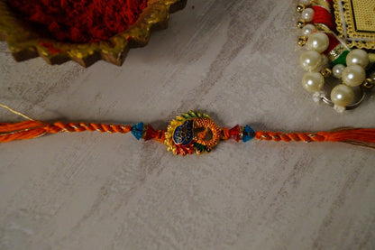 Peacock Stone and Gold Brass Thread Rakhi by Kamakhyaa with Brass, Festive Wear, Jewellery, Multicolor, Natural Materials, Natural Threads, Rakhi, Rakhis Ready to Ship, Regular Fit, Upcycled, Zari Threads at Kamakhyaa for sustainable fashion